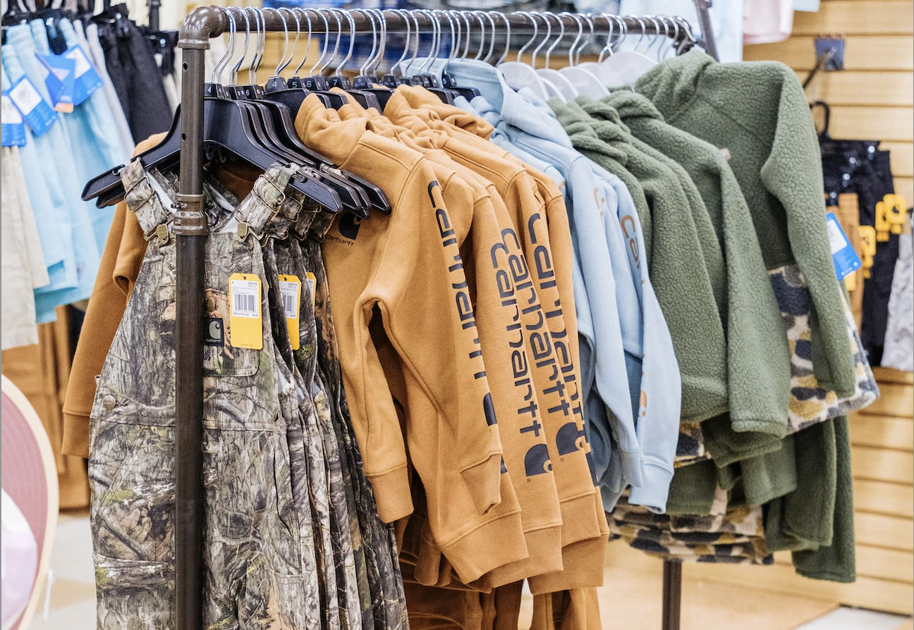 children’s clothing featuring camouflage overalls, tan and blue Carhartt hoodies, and green fleece jackets