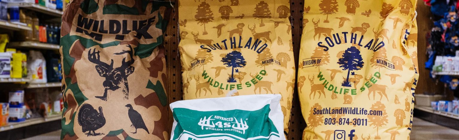 Display of wildlife food plot seed bags including Southland Wildlife Seed, Harvest Advantage, and 4S Advanced Wildlife Solutions — ideal for deer feeders, hunting plots, and Georgia hunting season preparation.
